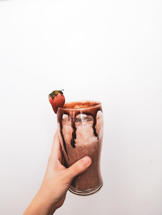 Person Holding Brown Ceramic Mug With Red Rose