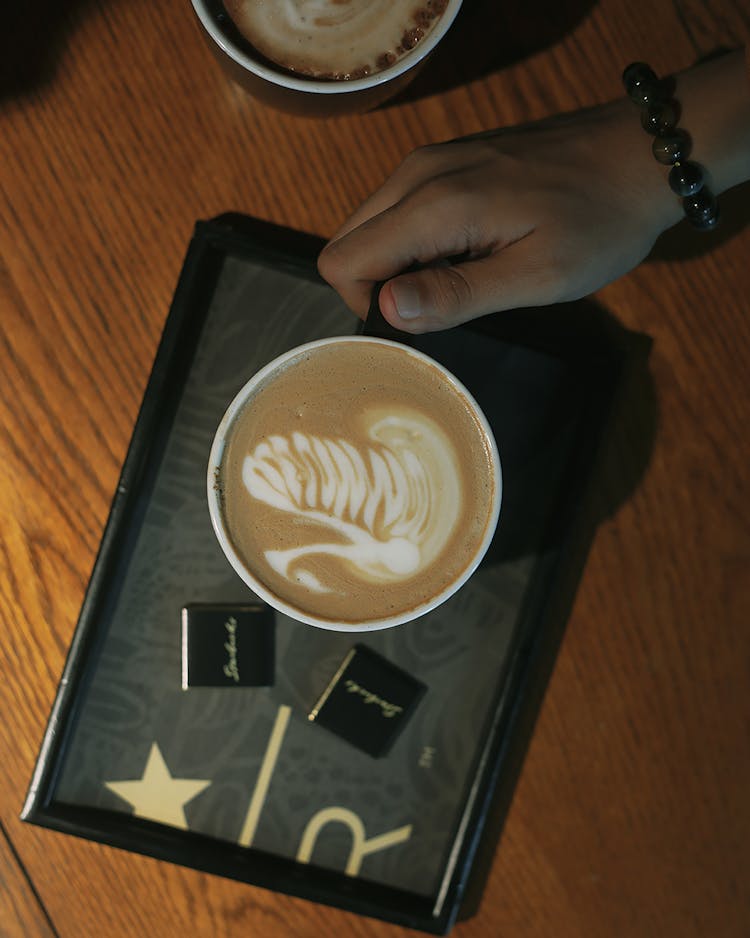 Hand Holding Cup Of Coffee On Tray 