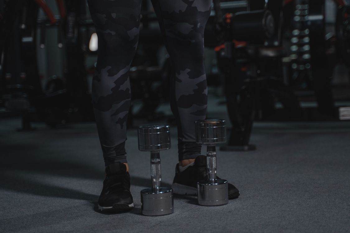 Equipamentos de musculação próximos a praticante em academia
