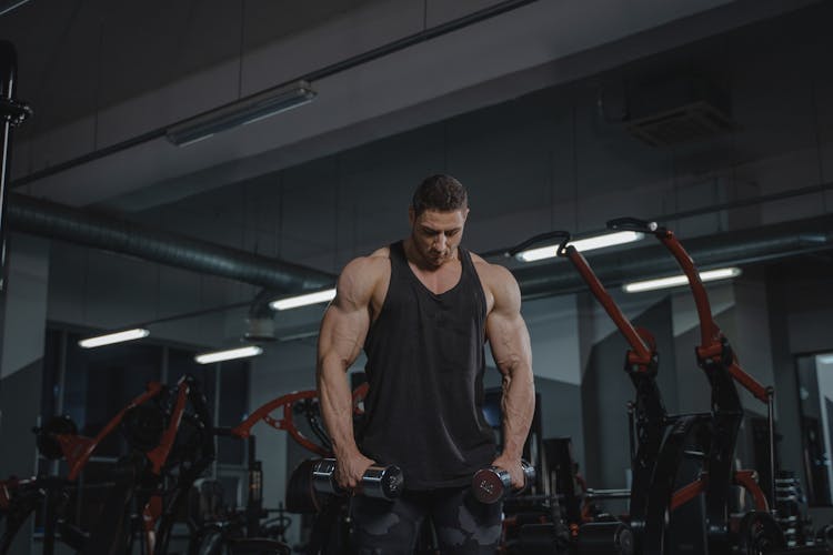 Man In Black Tank Top Holding Dumbbells 