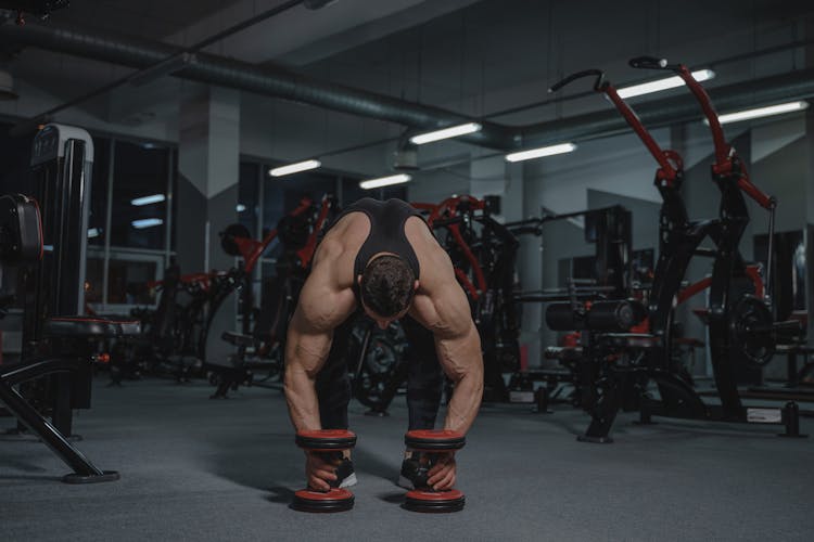 Man Getting The Dumbbells On The Floor 