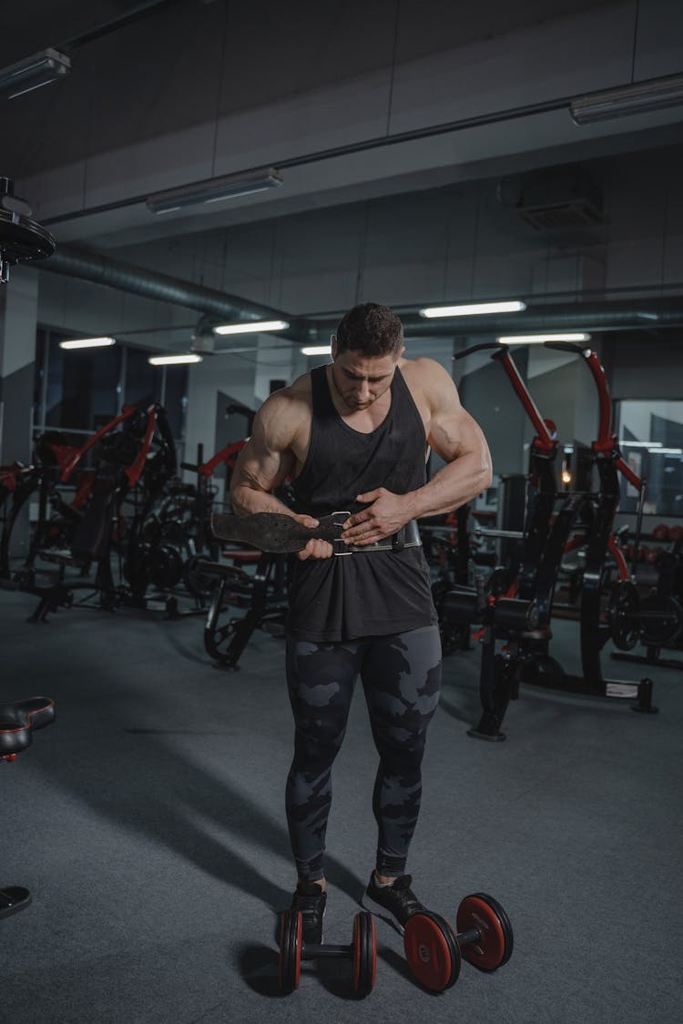 A Bodybuilder Putting On A Weightlifting Belt