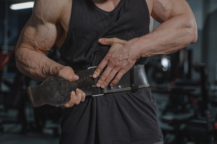 Man In Black Tank Top Putting Weightlifting Belt