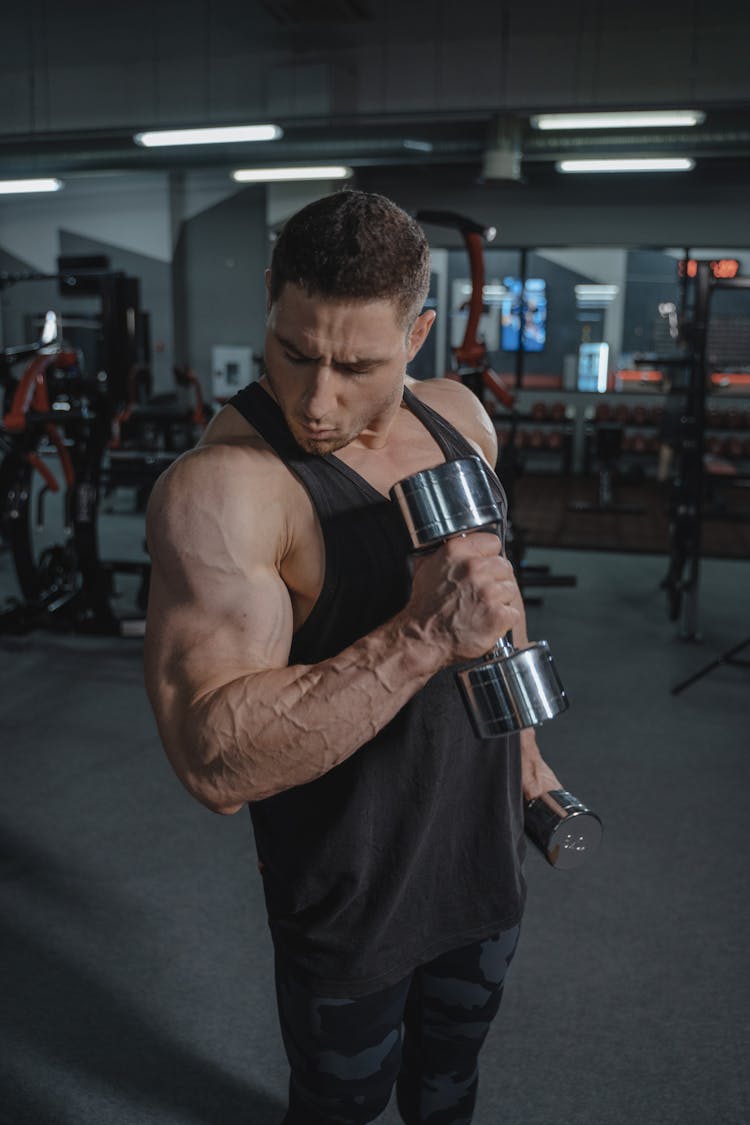 A Man Lifting Dumbbells At The Gym