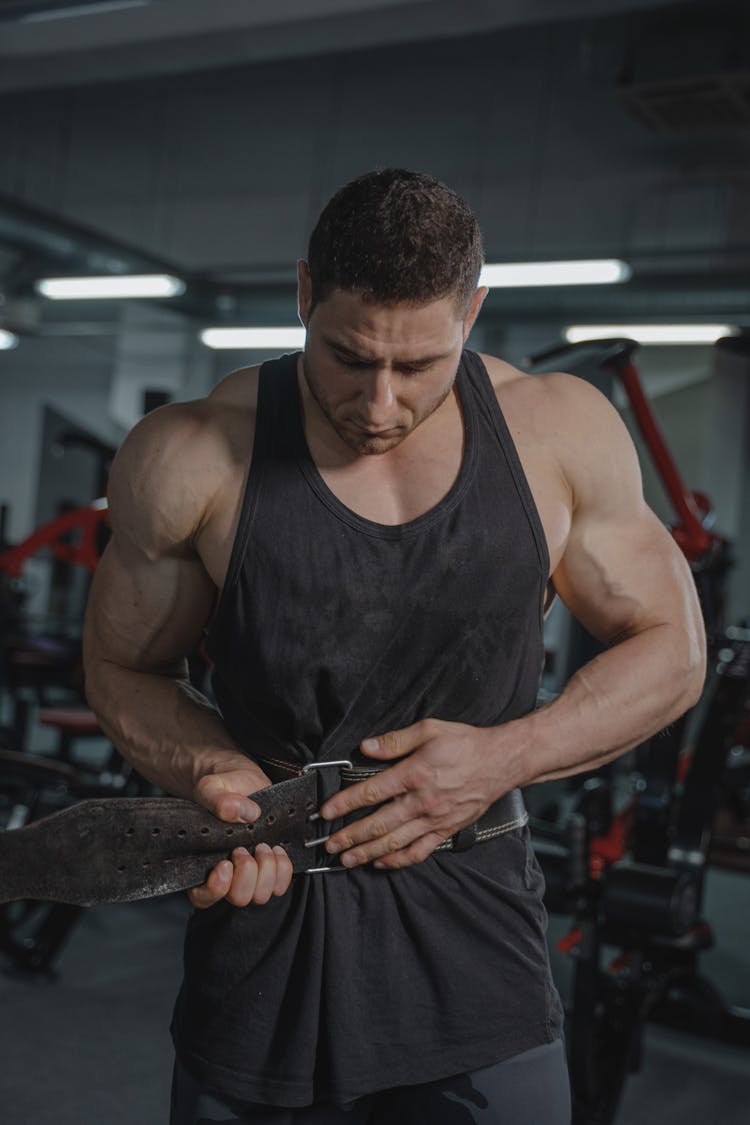 A Bodybuilder Putting On Weightlifting Belt 