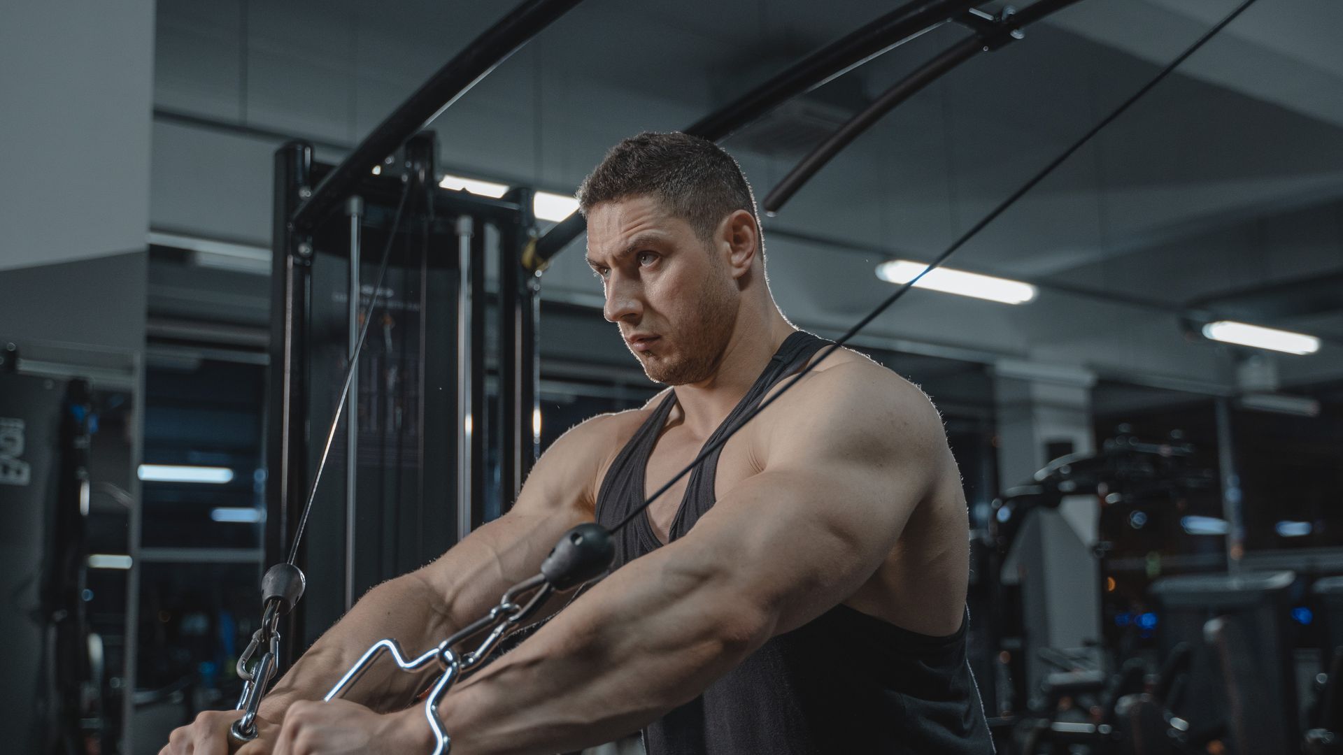 Ultimate Exercise Unlocking Guide: Enhance Your Workouts Muscular man exercising on a cable machine in a modern gym setting — ultimate exercise unlocking guide