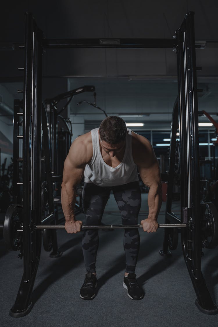 A Muscular Man Lifting A Barbell 