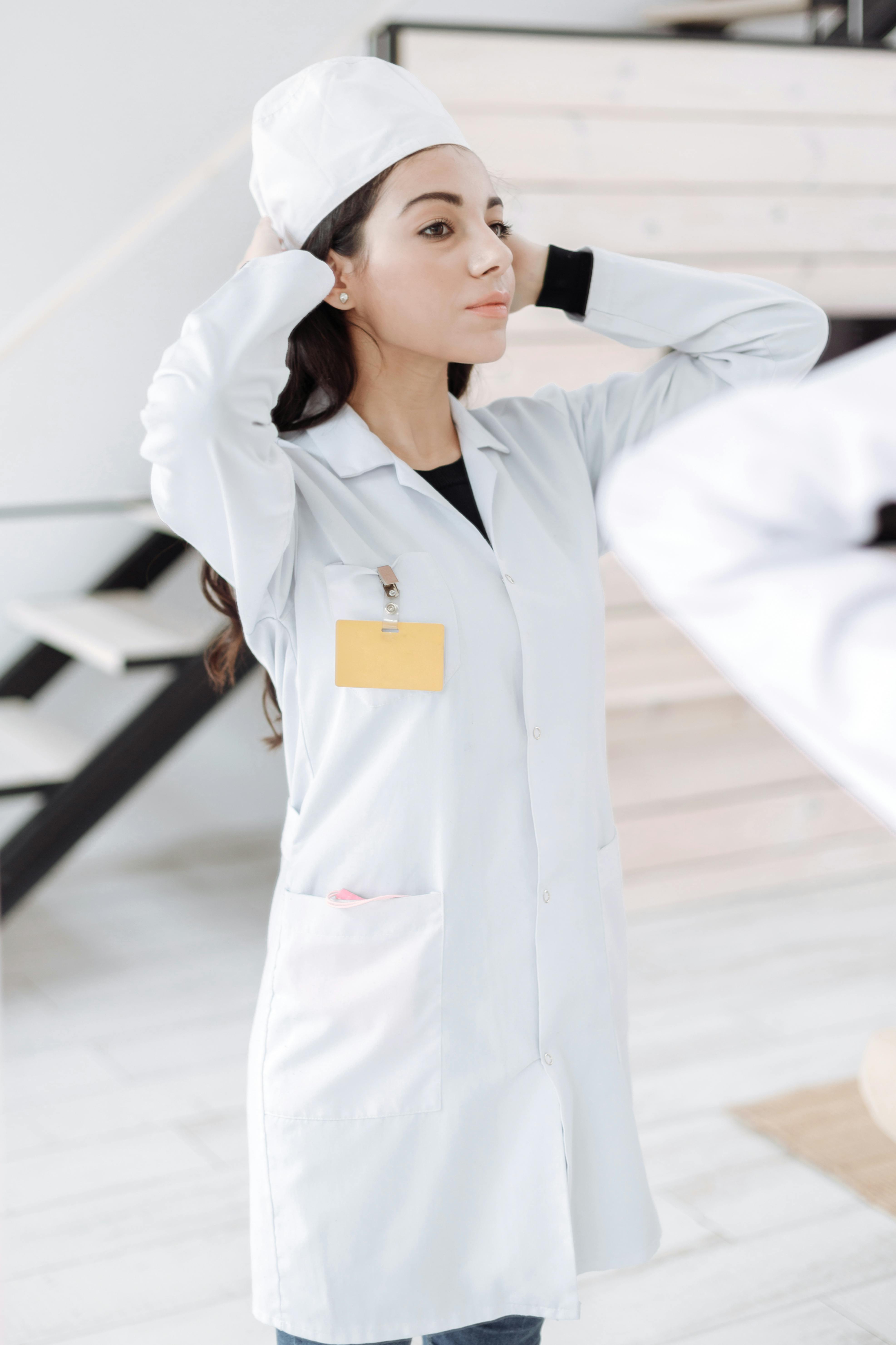 一名身穿白色制服的女子正了正帽子，准备开始医疗工作