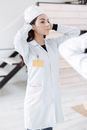 一名身穿白色制服的女子正了正帽子，准备开始医疗工作