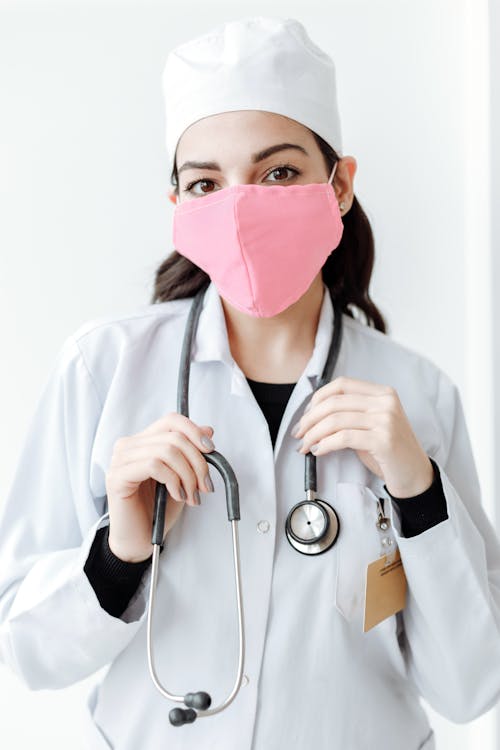 Free Person in White Scrub Suit With Pink Face Mask Stock Photo