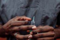 特写镜头中，一名医疗专业人员手持注射器，重点展现了医疗保健和医疗程序