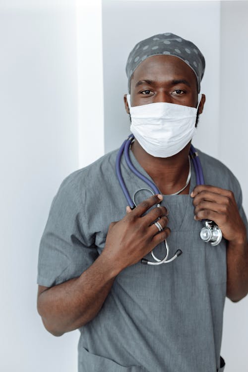 Free Man in Blue Scrub Suit With White Face Mask Stock Photo