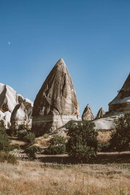 The iconic fairy chimneys in Cappadocia under a clear blue sky, a stunning natural wonder.