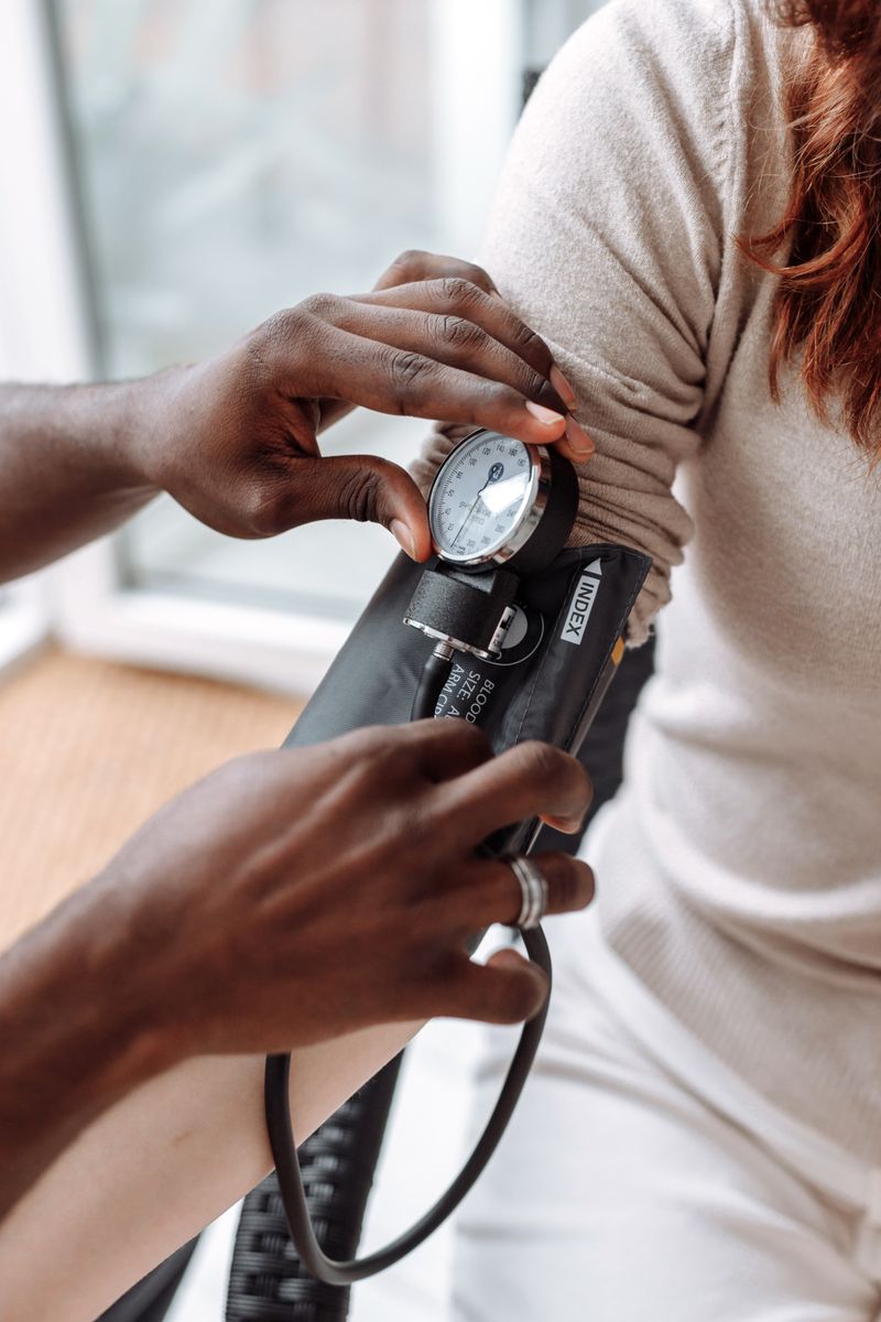 A clinician checks a Black patient's blood pressure with a cuff and gauge. High blood pressure is the leading driver of heart disease in Black women, and only about 1 in 4 has it controlled.