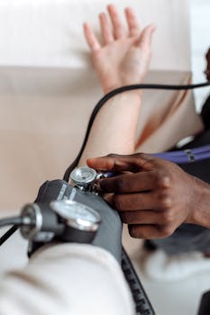 Close-up of a healthcare professional measuring a patient's blood pressure for a medical check-up.