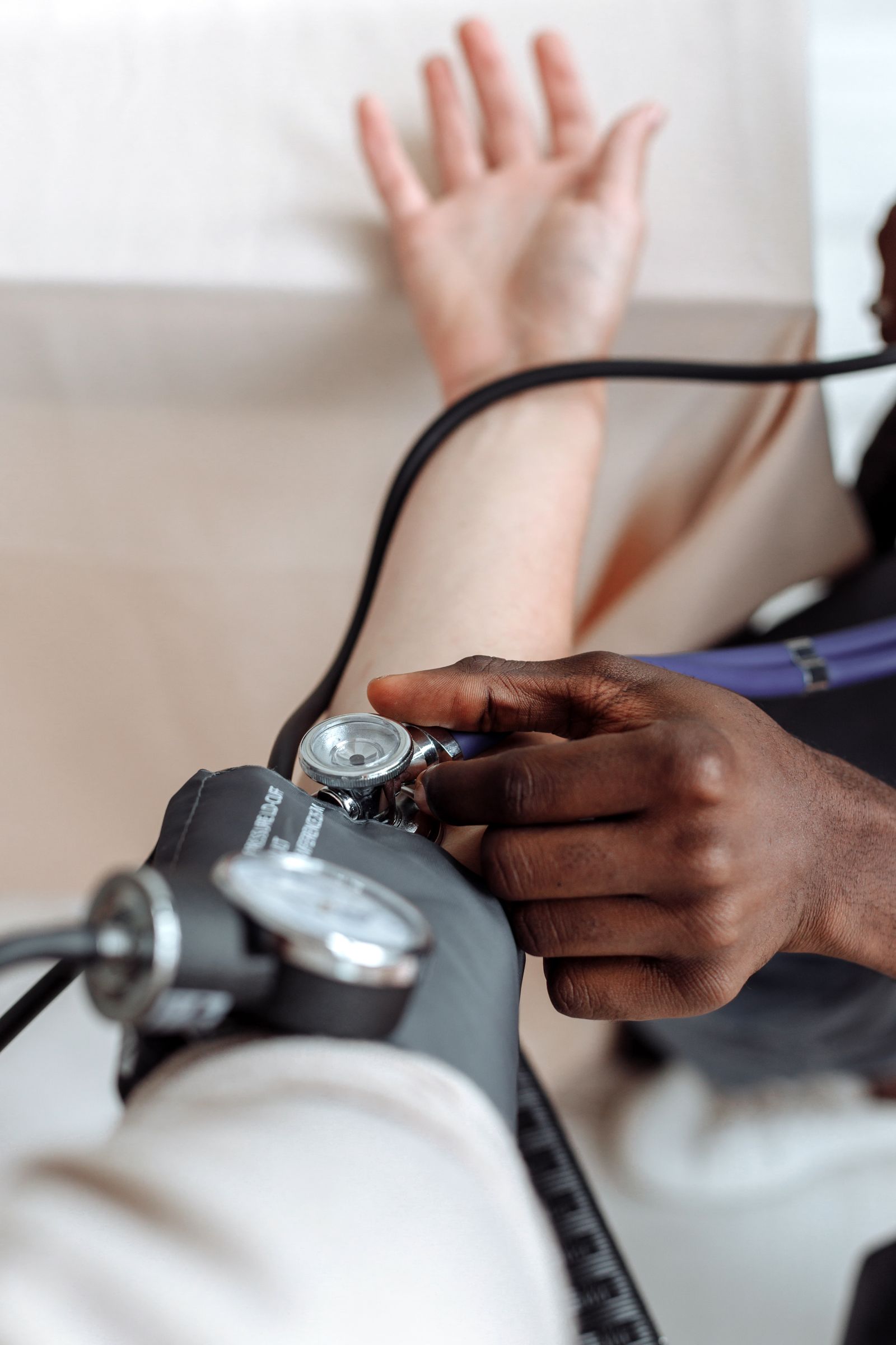 Healthcare professional checking a person's blood pressure with a cuff.