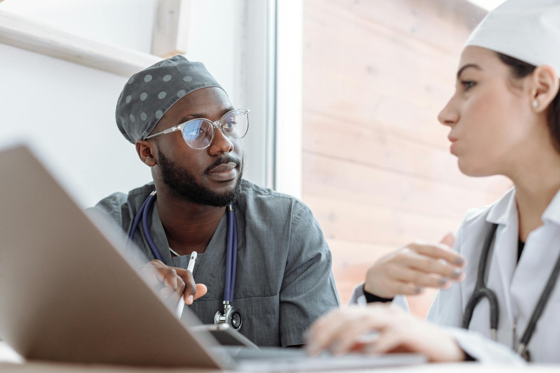 Two healthcare workers in conversation, focusing on collaboration and patient care.