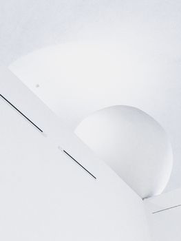 Sleek modern architecture featuring a minimalist ceiling with geometric shapes and light accents indoors.