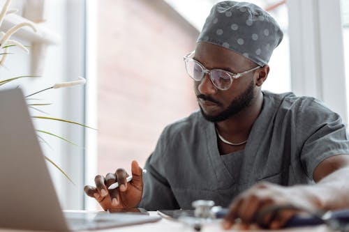 A Medical Practitioner Using Electronic Gadgets at Work