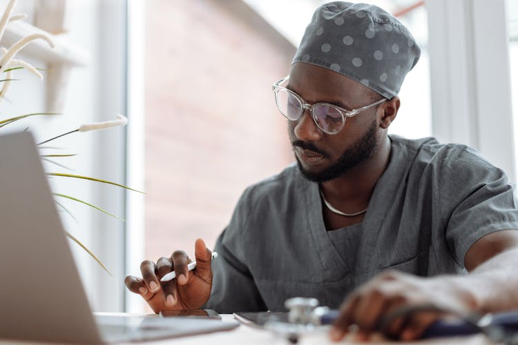 A Medical Practitioner Using Electronic Gadgets At Work