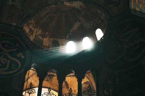 Free Captivating view of Hagia Sophia's interior showcasing sunrays illuminating the domed ceiling and Islamic art. Stock Photo