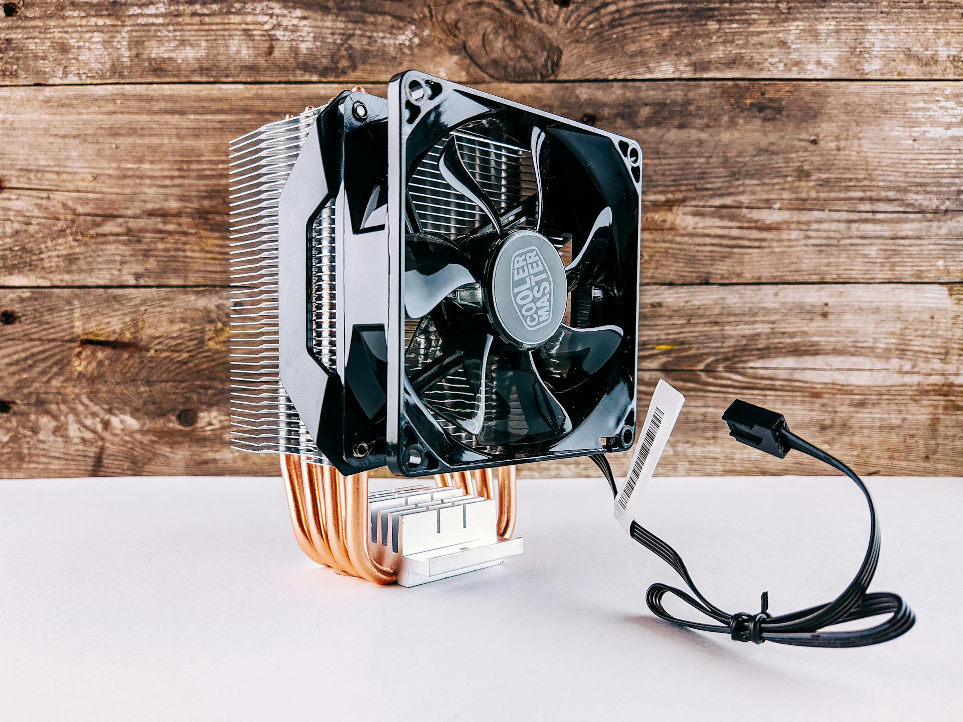 Detailed close-up of a CPU cooling fan and heatsink on wooden background, highlighting modern technology.