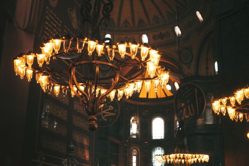Free Illuminated chandeliers inside Hagia Sophia Grand Mosque, showcasing architectural elegance and historic charm. Stock Photo