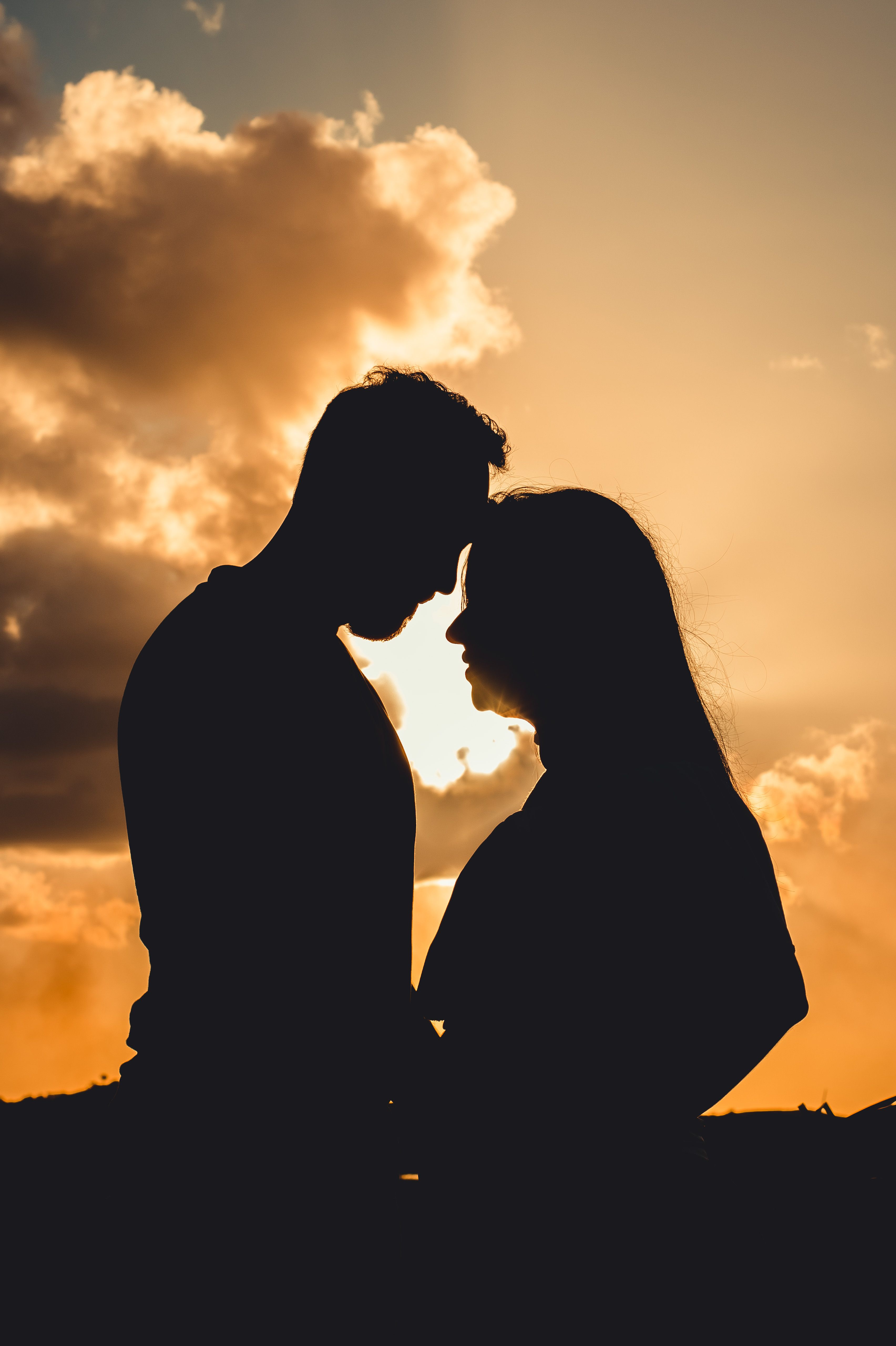 Silhouettes of anonymous couple embracing in sunshine · Free Stock Photo