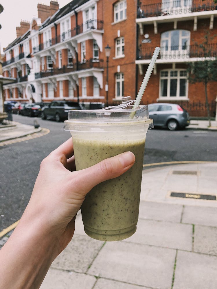 Photo Of Person Holding A Cup Of Matcha Smoothie