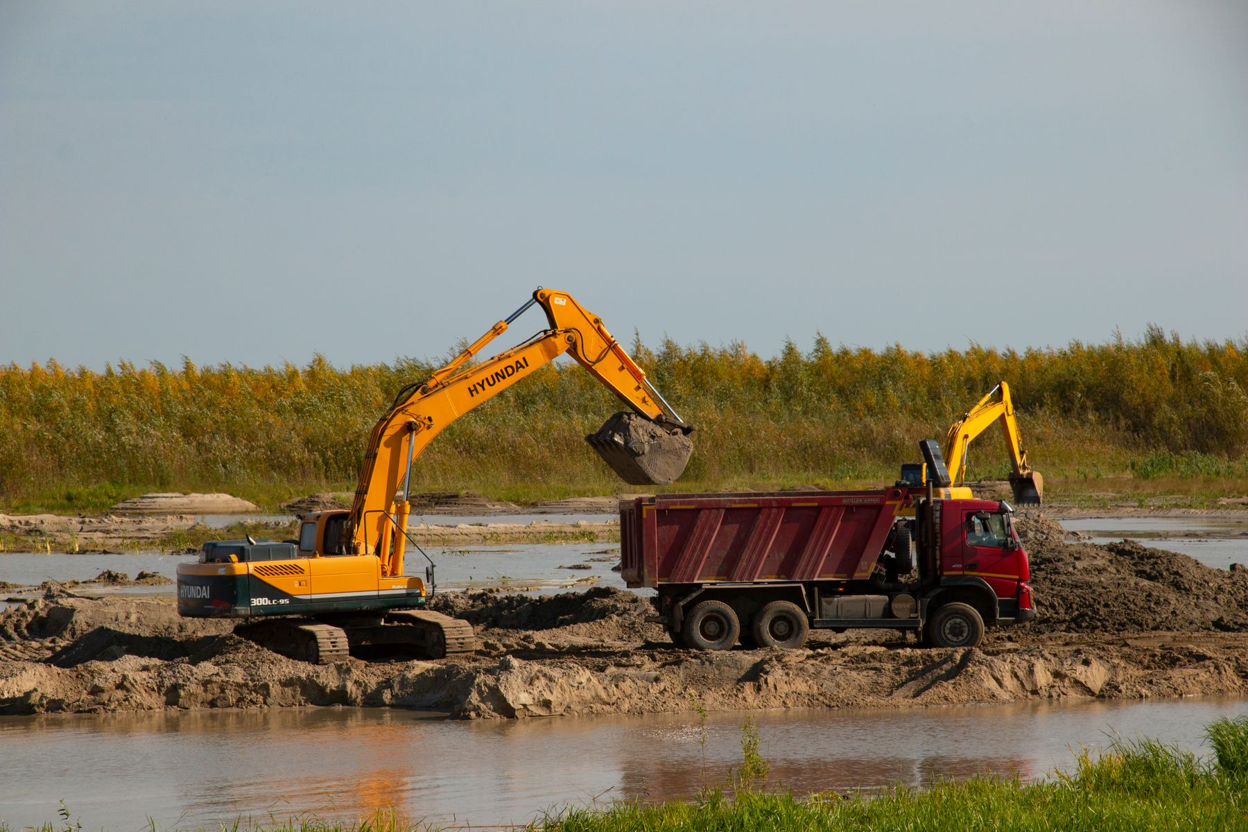 Civil excavator and truck working on site