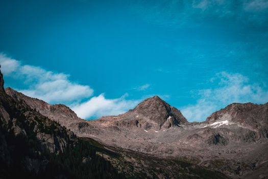 Scenery view of rough mounts covered with green plants against blue cloudy sky