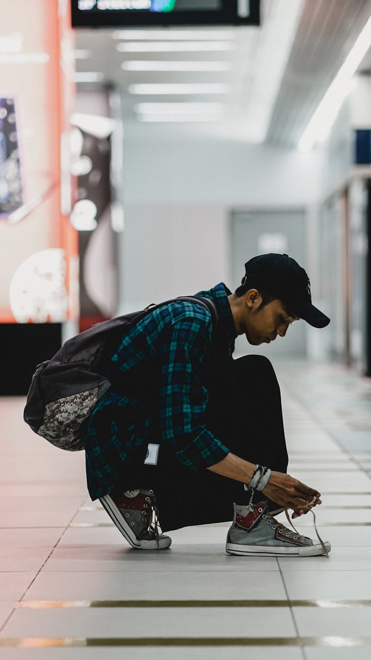 Man Tying His Shoes At Train Station