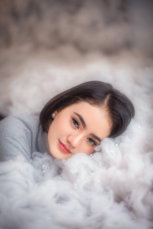 Free Calm young woman lying on soft fur plaid Stock Photo