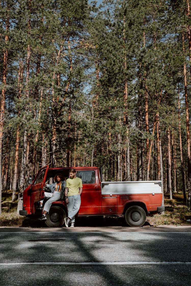 Man In Yellow Shirt And Gray Pants Standing Beside Red And White Pick Up Truck