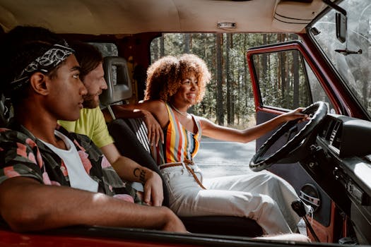 Young friends on a joyful summer road trip in a vintage car through the woods.