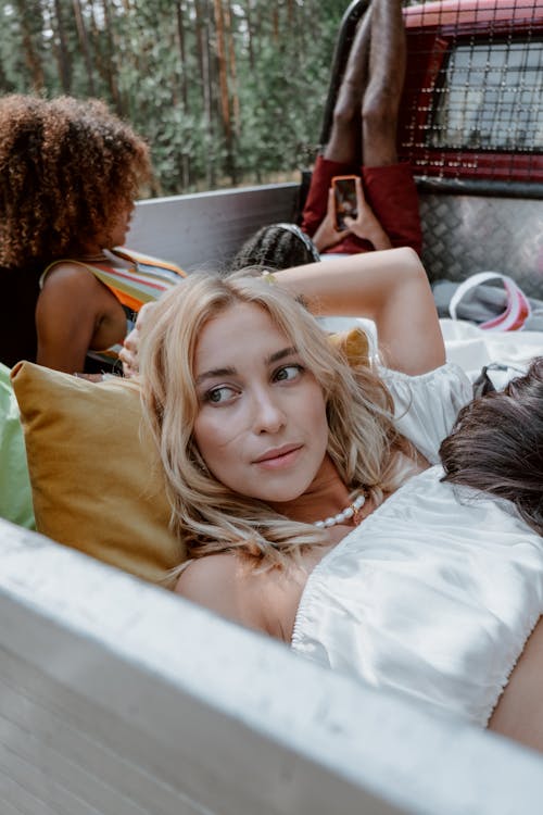 Free A Woman in Crop Top Shirt Lying Down in the Back of the Truck with Friends Stock Photo