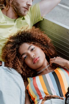 一对穿着色彩缤纷服装的夫妇在户外放松地躺着，神情平静