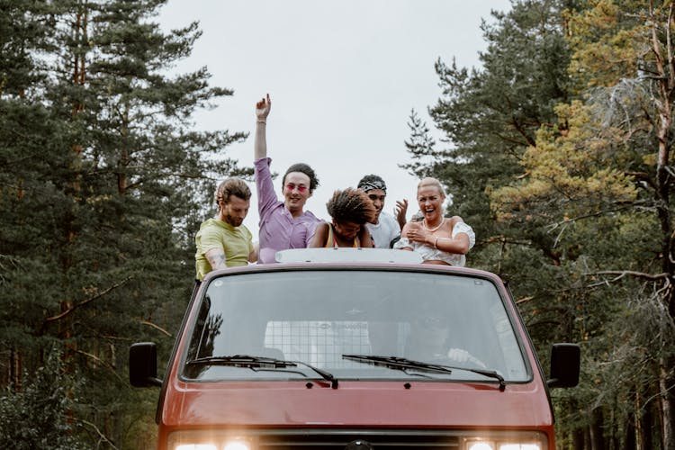 Friends Having Fun While Riding At The Back Of A Pickup Truck