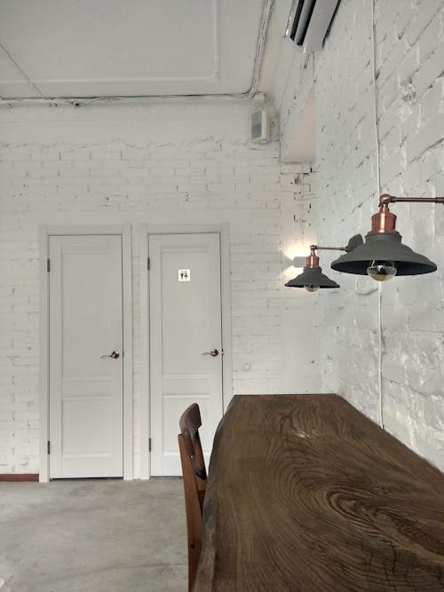 Free A Wooden Table and Sconces on a Brick Wall Stock Photo