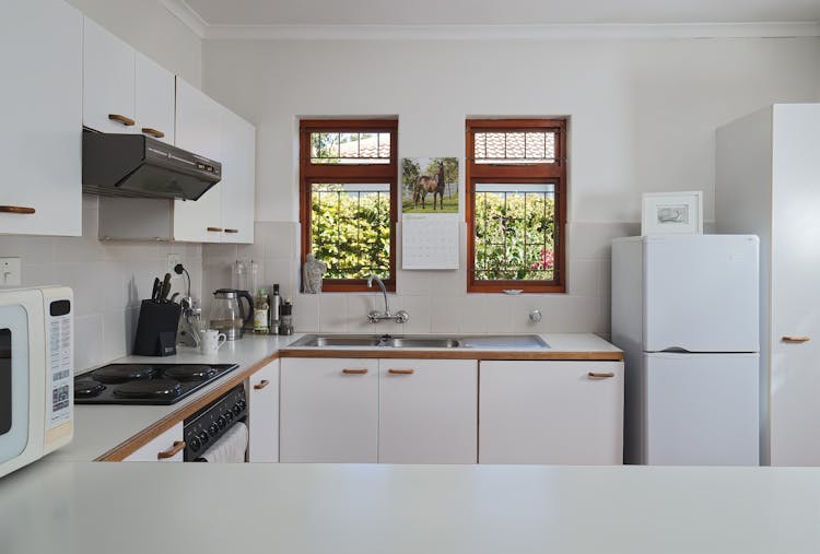 A Clean Kitchen With Cupboards And Kitchenware