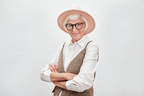 Mujer mayor con sombrero rosa y gafas