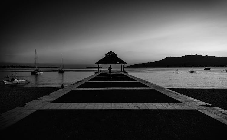 Person Walking Across Pier