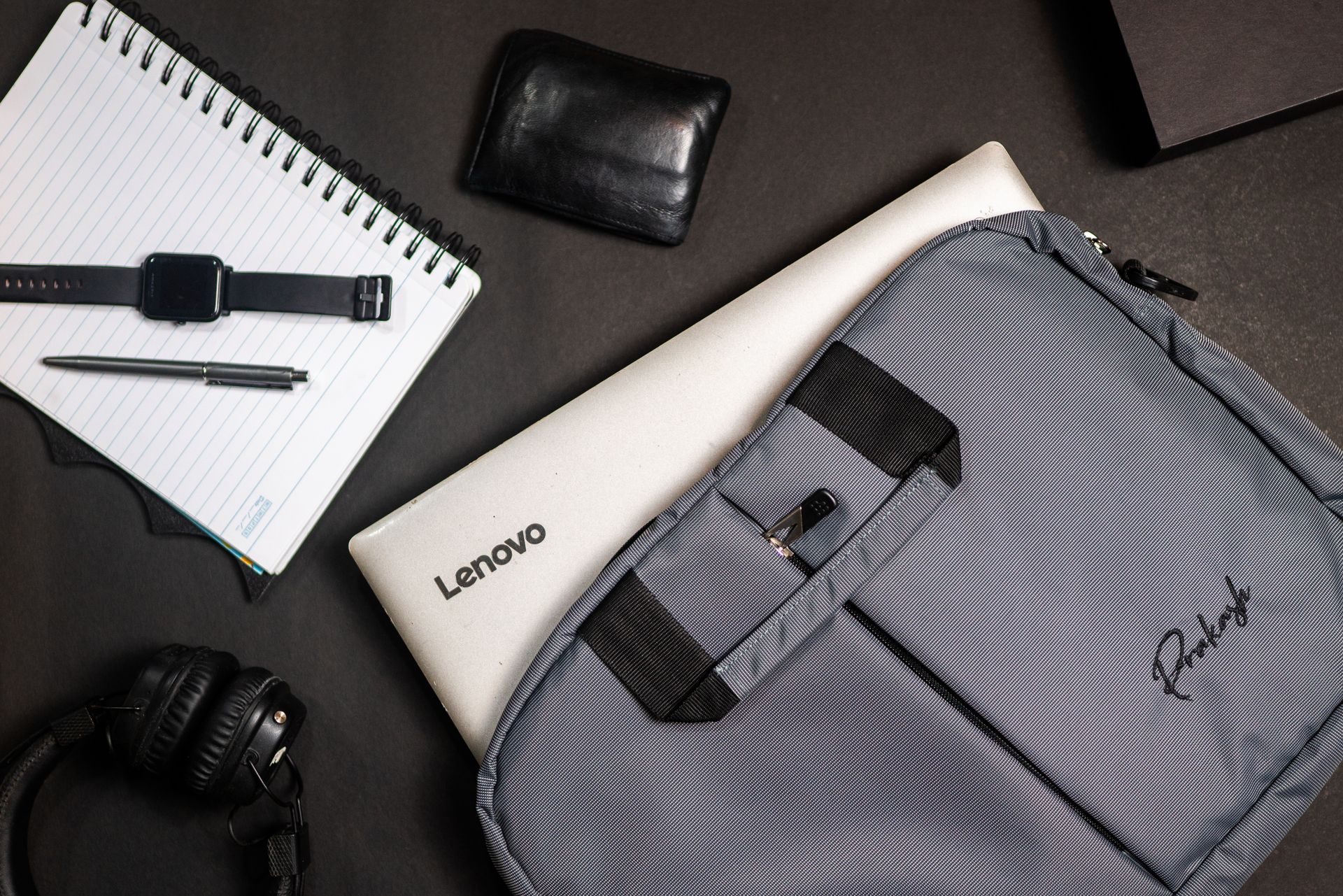 Top view of modern office essentials including a laptop, notebook, and accessories.