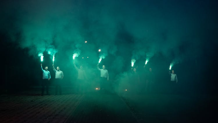 Elegantly Dressed Men Holding Blue Flares 