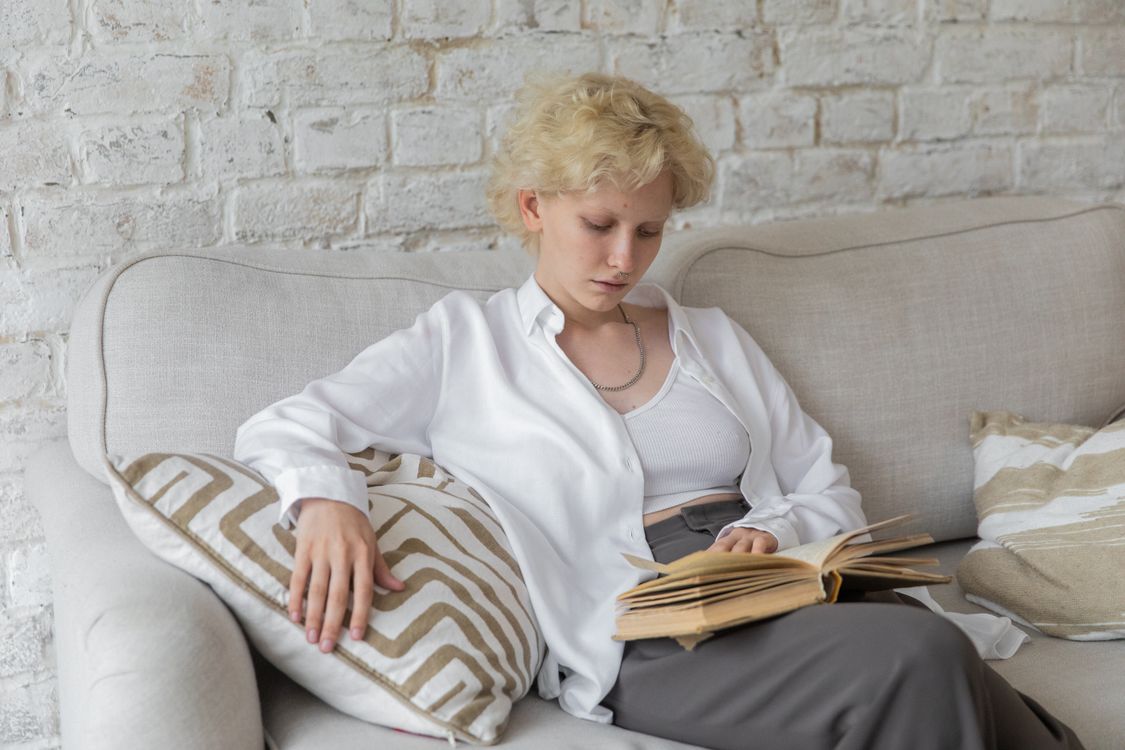 Woman reading on a sofa during a quiet evening at home