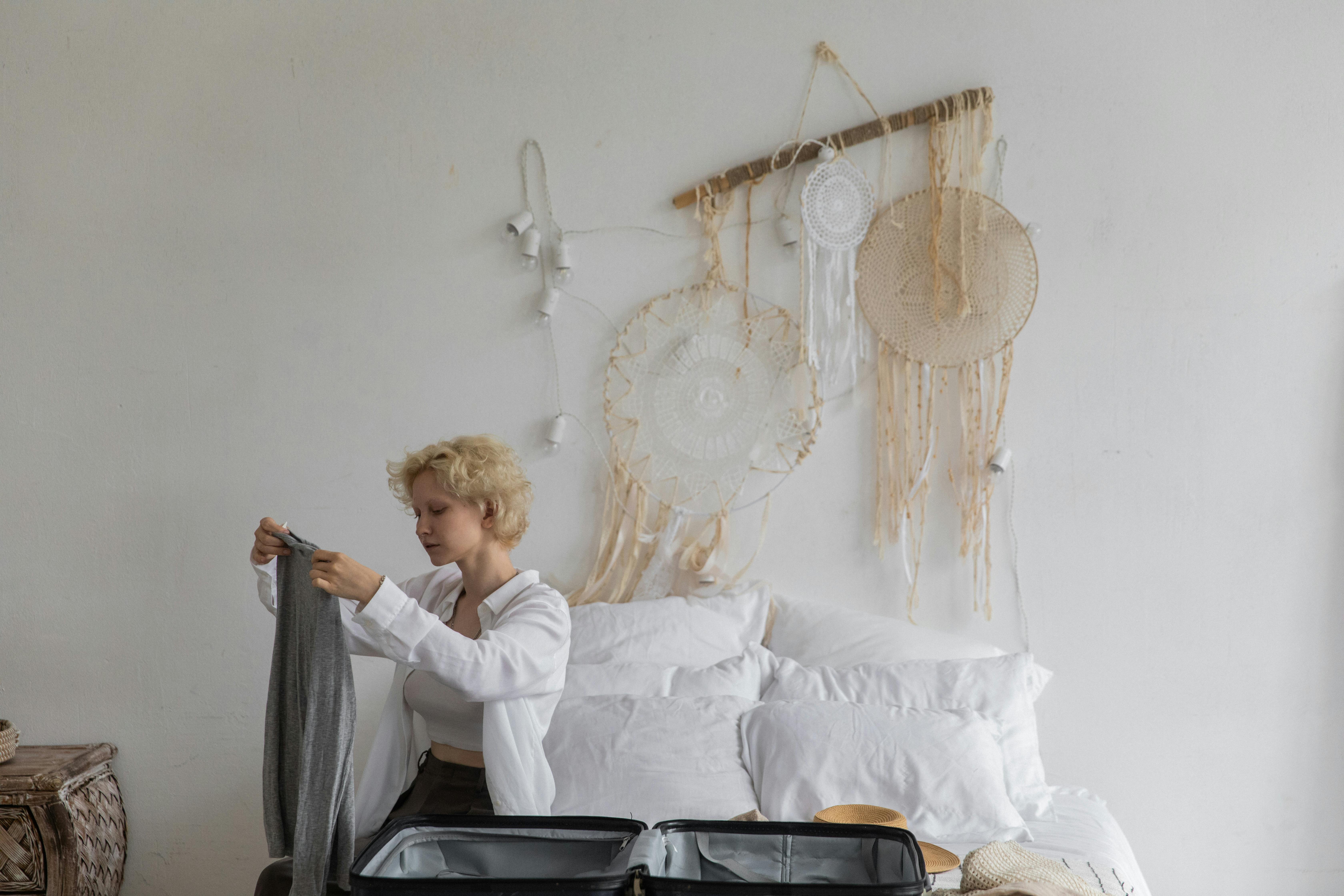 Young woman packing luggage in bedroom at home stock photo