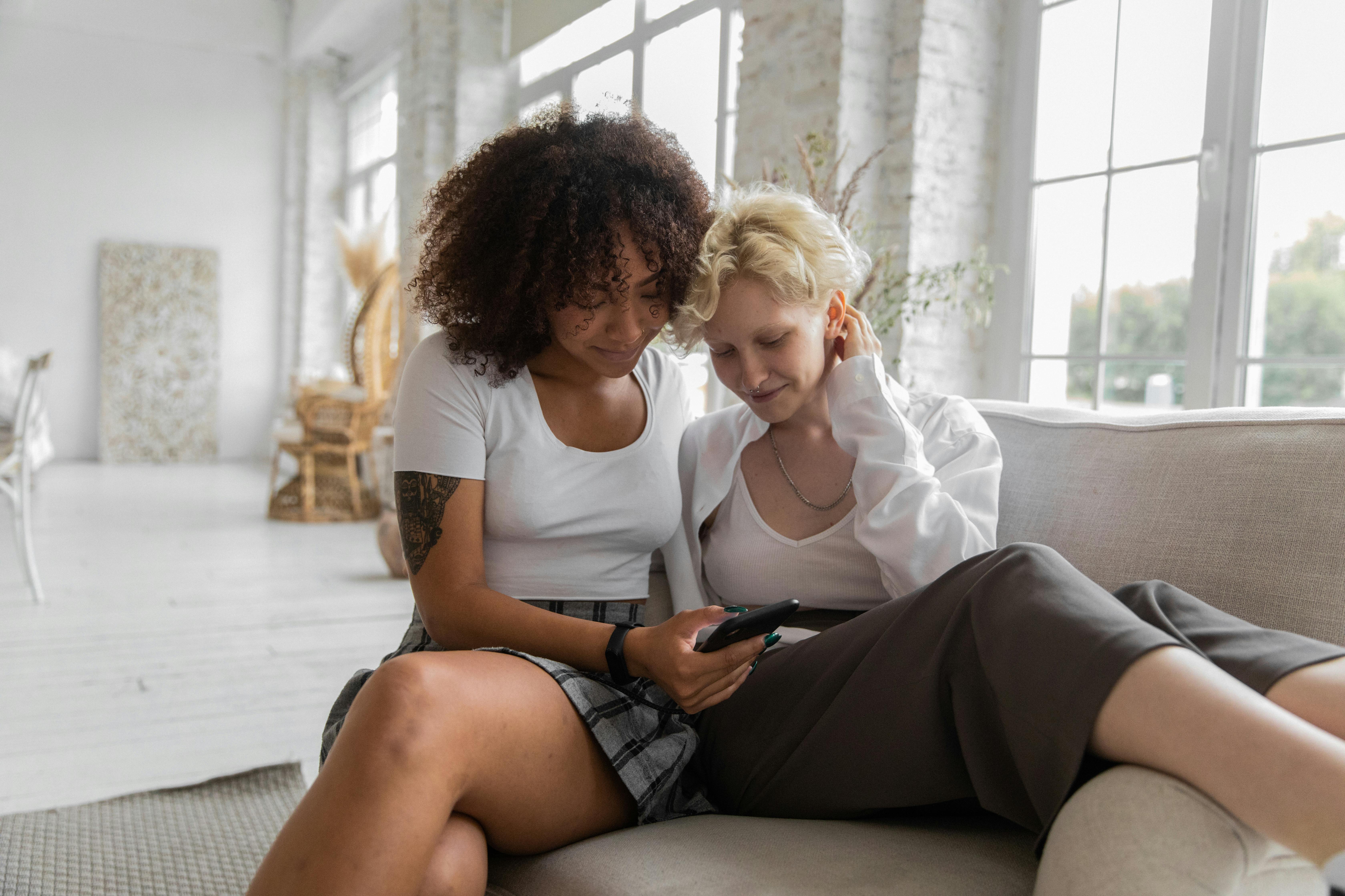 happy lesbian couple browsing mobile phone