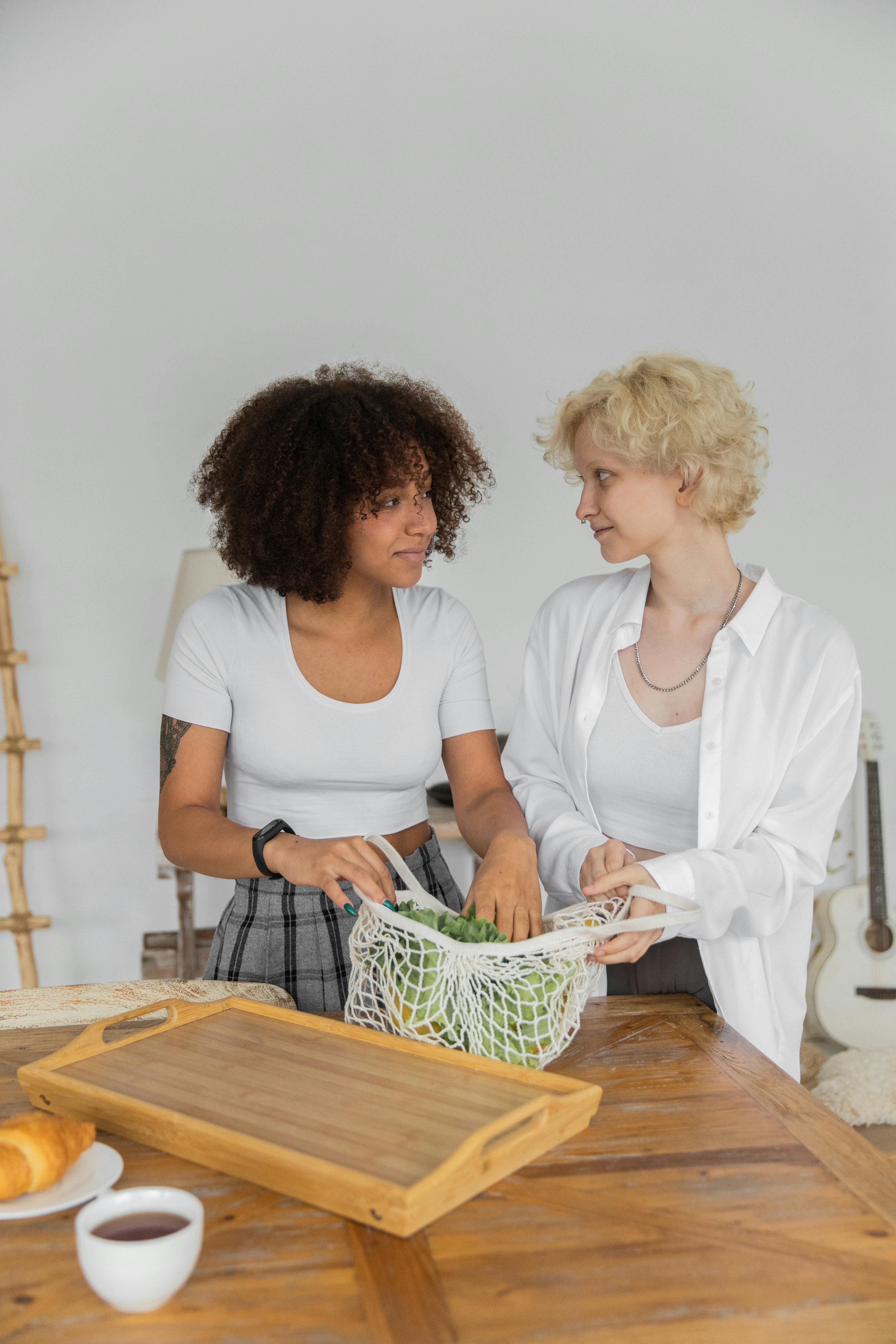 diverse lesbian couple unpacking string bag