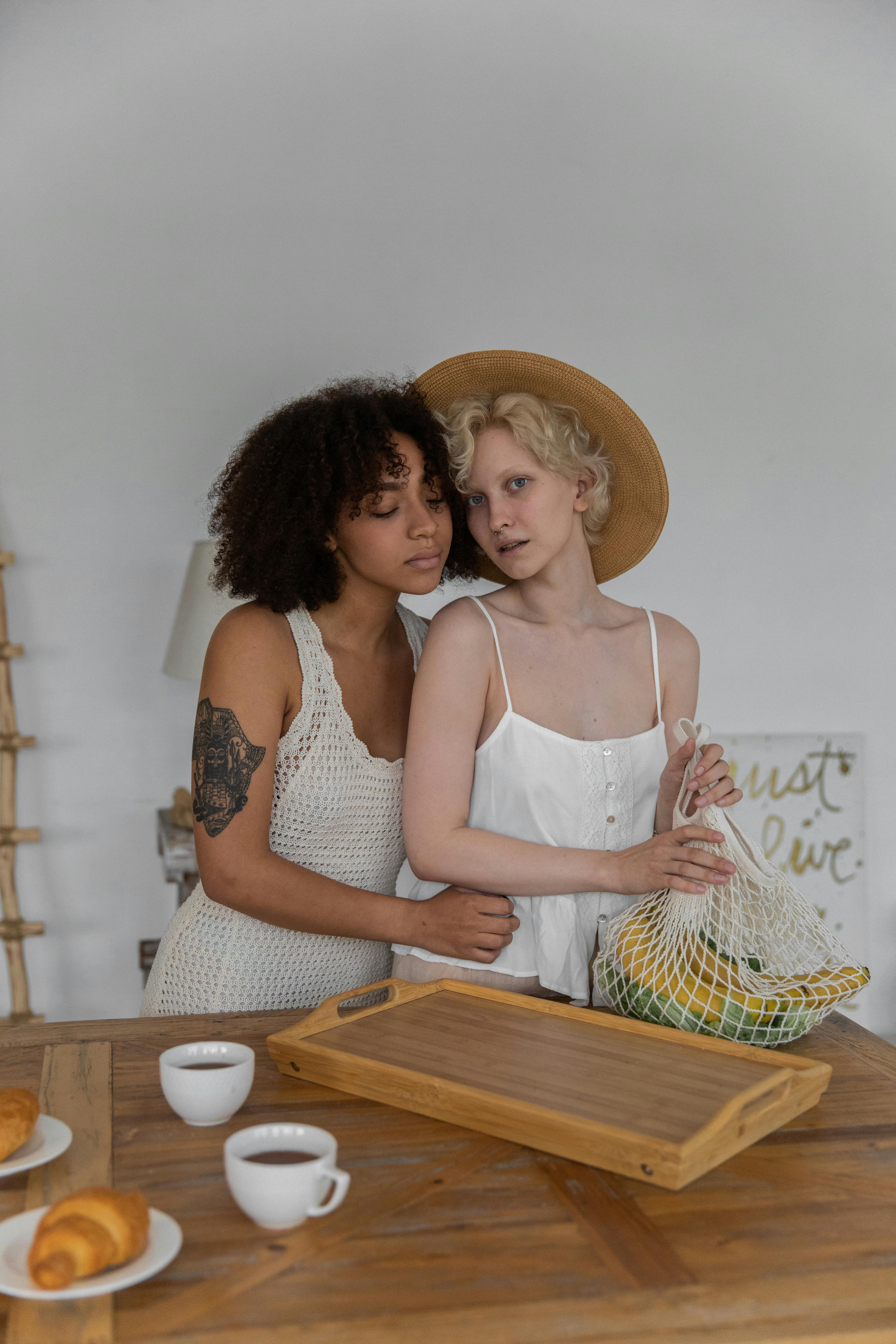 multiethnic lesbian couple embracing while preparing breakfast