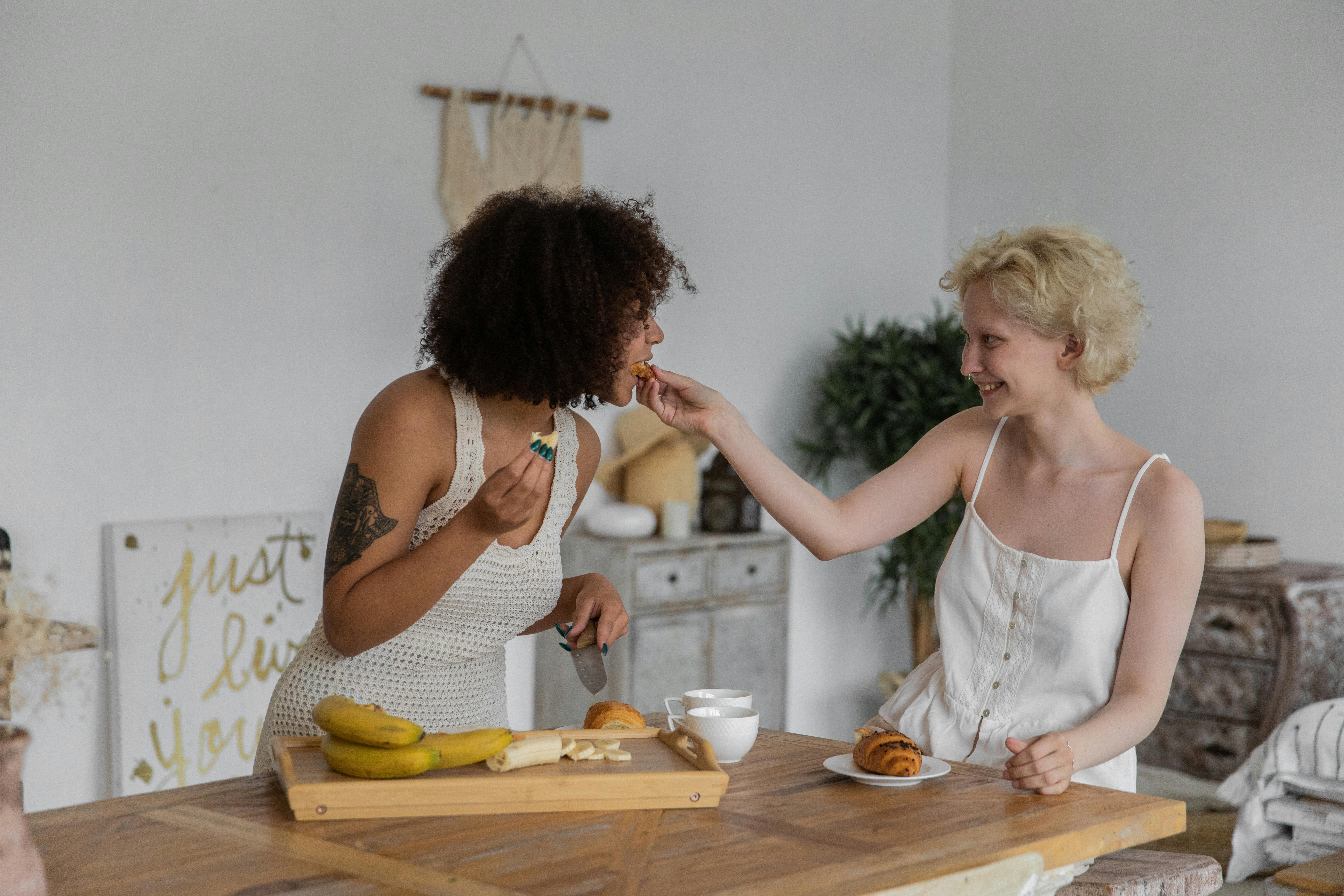 happy multiethnic girlfriends preparing breakfast together